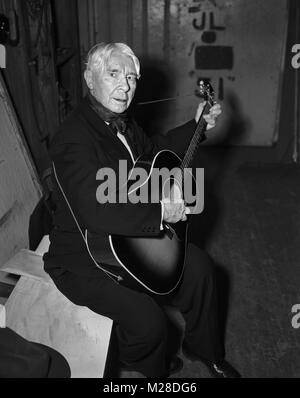 Poeta e scrittore Carl Sandburg pratiche backstage di chitarra prima di eseguire ad una cena in Chicago. Ottobre 31, 1957; fu onorato da Chicago e presentato una lapide con le parole che aveva scritto circa le dinamiche di Chicago. Foto Stock