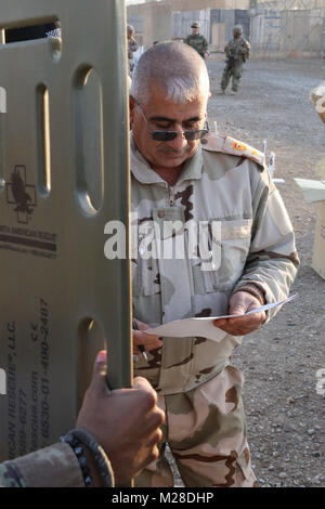 Un esercito iracheno officer esamina la documentazione per spineboards per essere ricevuti nel corso di una consegna di attrezzature mediche per l'esercito iracheno presso la gamma Besmaya complessa, Iraq, Gennaio 28, 2018. Gli Stati Uniti offre la formazione e le attrezzature esaminate le forze di sicurezza irachene attraverso la difesa nazionale atto di autorizzazione FY 2015; Iraq addestrare ed equipaggiare fondo. Formazione e attrezzature è a sostegno della Combined Joint Task Force - Funzionamento inerenti risolvere la missione per sconfiggere e negare ISIS rifugi sicuri mediante la creazione e attivazione di forze irachene a difendere e proteggere il loro paese dal terrorismo. (U.S. Esercito Foto Stock