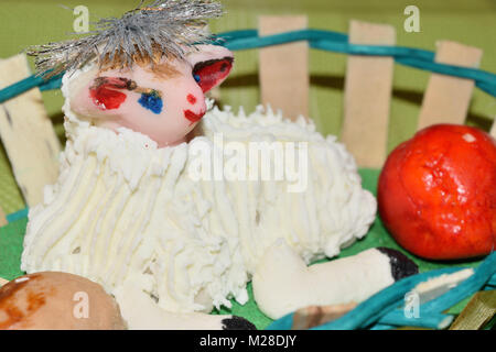 Close up di marzapane agnello pasquale e la frutta in un cesto Foto Stock