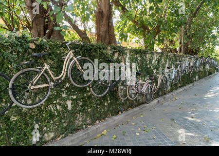 Alcune biciclette sono appesi al muro in una strada di Bangkok, Thailandia Foto Stock