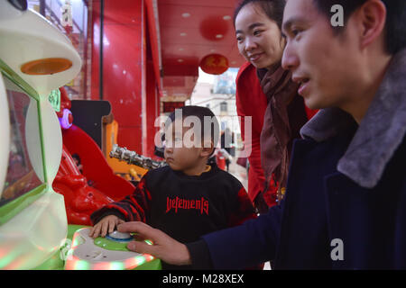 (180206) -- SHISHI, 6 febbraio 2018 (Xinhua) -- Huang Hailong e sua moglie di accompagnare il loro figlio più giovane Cong Cong sui giochi in Shishi City, a sud-est della Cina di provincia del Fujian, Gennaio 31, 2018. Huang Hailong, un lavoratore migrante da Suining città del sud-ovest della Cina di provincia di Sichuan, ha lavorato in una fabbrica di abbigliamento in Shishi per dieci anni. Pur vivendo con la moglie e il figlio più giovane Cong Cong, Huang è ancora mancante i suoi genitori e il figlio maggiore che vivono nella zona montuosa del Sichuan. Quest'anno, al fine di risparmiare denaro, Huang ha deciso di tornare da solo alla sua città natale per trascorrere la Festa di Primavera wit Foto Stock