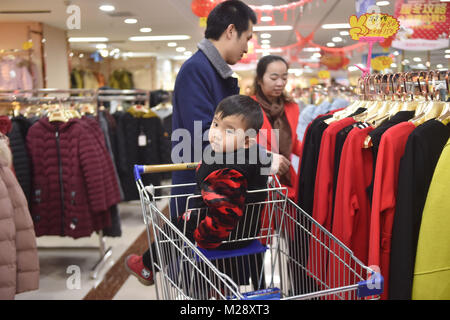 (180206) -- SHISHI, 6 febbraio 2018 (Xinhua) -- Huang Hailong, insieme con la moglie e il figlio più giovane, negozi nuovo anno le merci in un supermercato di Shishi City, a sud-est della Cina di provincia del Fujian, Gennaio 31, 2018. Huang Hailong, un lavoratore migrante da Suining città del sud-ovest della Cina di provincia di Sichuan, ha lavorato in una fabbrica di abbigliamento in Shishi per dieci anni. Pur vivendo con la moglie e il figlio più giovane Cong Cong, Huang è ancora mancante i suoi genitori e il figlio maggiore che vivono nella zona montuosa del Sichuan. Quest'anno, al fine di risparmiare denaro, Huang ha deciso di tornare da solo alla sua città natale per trascorrere la molla F Foto Stock