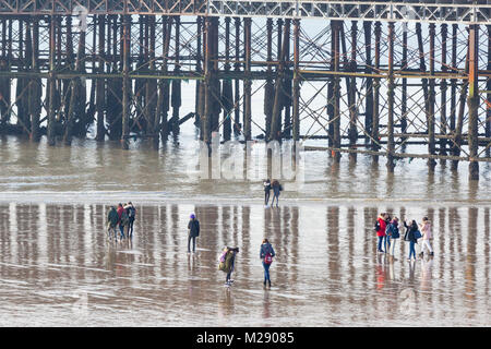 Hastings, East Sussex, Regno Unito. 6 febbraio, 2018. Regno Unito: Meteo luminoso e soleggiato ma freddo per iniziare la giornata in Hastings questa mattina. Un sacco di persone stanno approfittando di un insolitamente bassa marea, con alcune passeggiate sotto il molo di Hastings. Le temperature sono non dovrebbe superare i 2 C gradi. Photo credit: Paolo Lawrenson / Alamy Live News Foto Stock