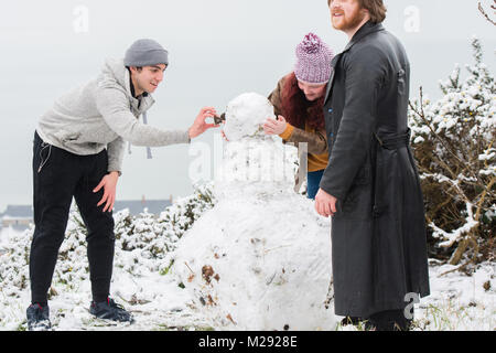 Aberystwyth, Ceredigion nel Galles, martedì 06 FebJanuary 2018 UK Meteo: studenti da Aberystwyth University prendere tempo fuori dal loro gli studi universitari per fare un pupazzo di neve sulla collina che si affaccia sulla città di mare , dopo una mattinata di neve pesante ha coperto la zona , trasformandolo in un paesaggio bianco, in una fredda mattina di febbraio il Met Office ha rilasciato un 'giallo' avvertenza per la neve e il ghiaccio, come una banda di nevischio e neve si sposta da ovest, a coprire gran parte del Galles e il nord dell'Inghilterra Photo credit: Keith Morris / Alamy Live News Foto Stock