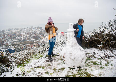Aberystwyth, Ceredigion nel Galles, martedì 06 FebJanuary 2018 UK Meteo: studenti da Aberystwyth University prendere tempo fuori dal loro gli studi universitari per fare un pupazzo di neve sulla collina che si affaccia sulla città di mare , dopo una mattinata di neve pesante ha coperto la zona , trasformandolo in un paesaggio bianco, in una fredda mattina di febbraio il Met Office ha rilasciato un 'giallo' avvertenza per la neve e il ghiaccio, come una banda di nevischio e neve si sposta da ovest, a coprire gran parte del Galles e il nord dell'Inghilterra Photo credit: Keith Morris / Alamy Live News Foto Stock