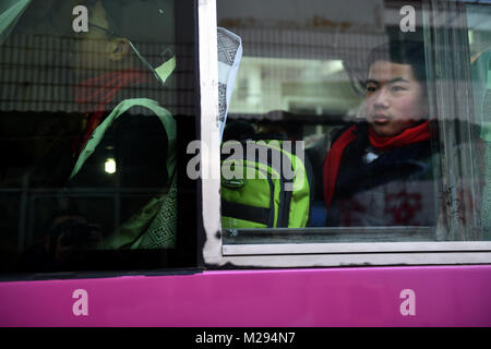 (180206) -- LONGXI, 6 febbraio 2018 (Xinhua) -- Sun Jianjun guarda attraverso la finestra di un pullman, in Longxi della Cina nord-occidentale della provincia di Gansu, Febbraio 2, 2018. Festival di primavera, o il nuovo anno lunare cinese, cade il 16 febbraio di quest'anno. Centinaia di milioni di cinesi ritorneranno alle loro città di appartenenza per riunioni di famiglia. 14-anno-vecchio Jianjun Sun e i suoi 15 compagni di scuola sono tra questi viaggiatori desiderosi torna alla home. Il 1 febbraio il primo giorno del 2018 Festival di Primavera di viaggio rush, hanno intensificato su un treno in Nantong dell oriente cinese della provincia di Jiangsu su un viaggio a casa che è più di duemila kil Foto Stock