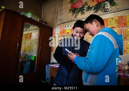 (180206) -- KANGLE, 6 febbraio 2018 (Xinhua) -- Sun Jianjun (L) e il suo giovane fratello sole Jianqiang giocare nel villaggio di Xinzhuang, Basong Township, Kangle contea di nord-ovest della Cina di Provincia di Gansu, Febbraio 2, 2018. Festival di primavera, o il nuovo anno lunare cinese, cade il 16 febbraio di quest'anno. Centinaia di milioni di cinesi ritorneranno alle loro città di appartenenza per riunioni di famiglia. 14-anno-vecchio Jianjun Sun e i suoi 15 compagni di scuola sono tra questi viaggiatori desiderosi torna alla home. Il 1 febbraio il primo giorno del 2018 Festival di Primavera di viaggio rush, hanno intensificato su un treno in Nantong dell oriente cinese della provincia di Jiangsu Foto Stock