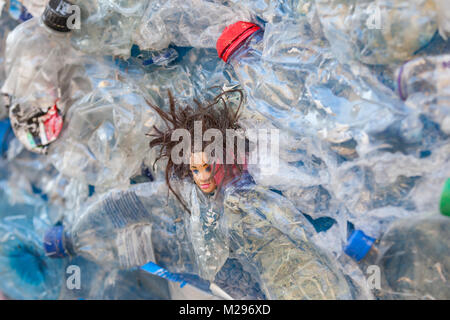 Dettaglio pallini di plastica dei rifiuti gettati le bottiglie di plastica, spazzatura e una bambola di plastica della testa dell acqua di inquinanti e degli oceani Foto Stock