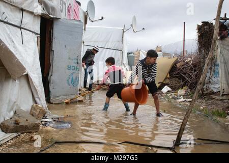 26 gennaio 2018 - Bekaa Valley, Libano - Giovani ragazzi siriano contribuire a cancellare i loro allagato tenda in un campo profughi in Libano Bekaa Valley, il Libano. Le tempeste invernali a creare enormi sfide per i rifugiati che vivono in questi campi..Il piccolo paese del Libano ospita attualmente più di 1 milioni di rifugiati siriani in fuga la loro casa per cercare sicurezza dal loro paese lacerato dalla guerra. (Credito Immagine: © Giovanni Owens/SOPA via ZUMA filo) Foto Stock