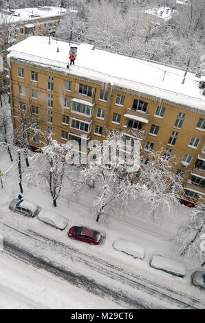 Bidello pulisce la neve dal tetto dopo la nevicata in Mosca Russia Foto Stock