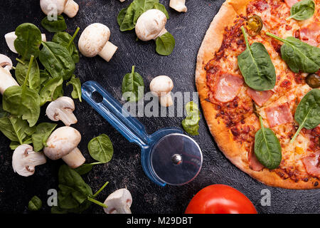 Top da vicino la vista sulla pizza accanto ai funghi, baby spinaci e t Foto Stock