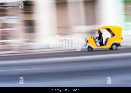 Cocotaxi, coco taxi, accelerando lungo la strada di El Malecon, Havana, Cuba, West Indies, dei Caraibi e America centrale Foto Stock