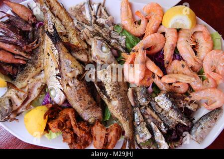 La cucina greca - tradizionale pesce alla griglia piastra con gamberetti, acciughe, sardine, calamari e altri pesci. Foto Stock