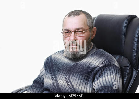 Vero uomo con la barba si siede su una sedia su sfondo bianco Foto Stock