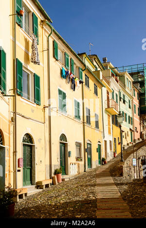 Storiche case tradizionali su ripidi acciottolate lane, shot su una soleggiata giornata invernale a Bogliasco e Genova, Italia Foto Stock