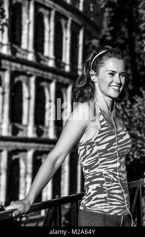 Gladiator ispirando allenamenti. Felice eleganti donna fitness nell'abbigliamento sportivo in Roma, Italia Cercando la distanza Foto Stock