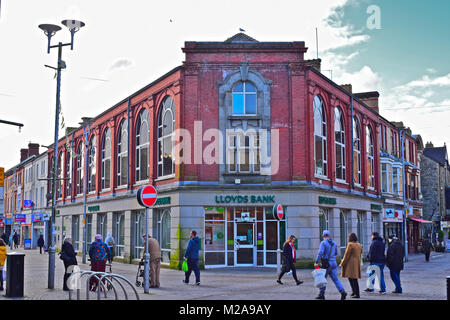 Persone che passano dalla Lloyds Bank Building a Bridgend Town Center - una grande banca nazionale mantenendo una presenza locale nella comunità locale. Foto Stock