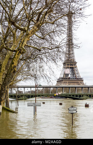 La Senna gonfi durante l'inverno episodio di allagamento del gennaio 2018, con la metà immerso della segnaletica stradale e le luci di strada in primo piano e l'Eiffel Foto Stock
