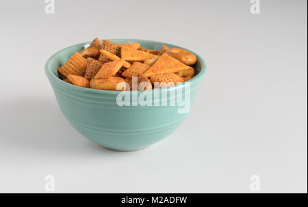 Un mix di piccoli snack in un recipiente su un bancone bianco. Foto Stock