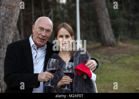 Padre e figlia di bere un bicchiere di vino nel giardino della loro casa Foto Stock