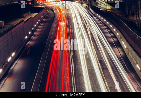 Città percorsi di luce di veloce vettura in movimento il traffico su strada in Londra di notte Foto Stock