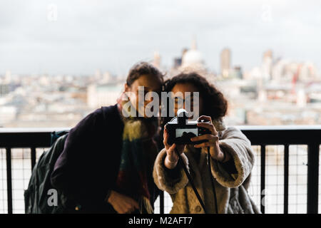 Londra - Febbraio 01, 2018: due giovani turisti gente tenendo selfie con telecamera in moderno London Foto Stock
