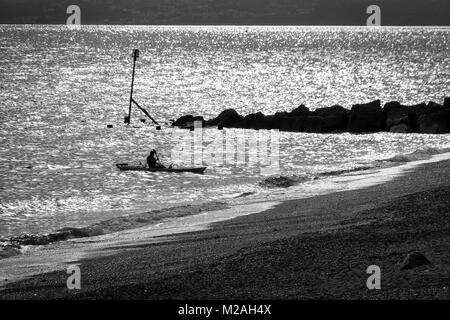 Pescatore in kayak, a West Bay, Dorset UK. Girato in bianco e nero. Foto Stock