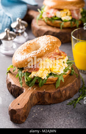 Ciambelle di pane con uova strapazzate, rucola e pancetta fritta Foto Stock