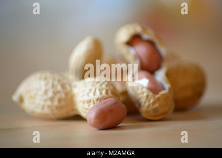 Qualsiasi chiuso e aperto arachidi giacciono su di un tavolo di legno. Foto Stock