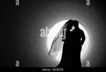 Crisi del matrimonio. Sposa e lo sposo le figure in un buio del tunnel Foto Stock