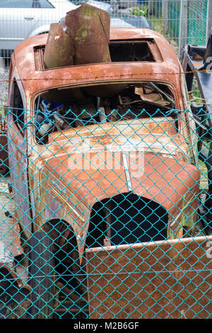 Unknown marca e modello di auto classica, disperato bisogno di restauro, in un angolo di un motore di riparazione della società cantiere in Whaley Bridge, Derbyshire. Foto Stock