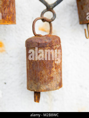 Close up di rusty campane su un fatto a mano metallo wind chime Foto Stock