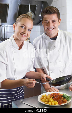 Ritratto di Chef femmina istruire il tirocinante nel ristorante cucina Foto Stock