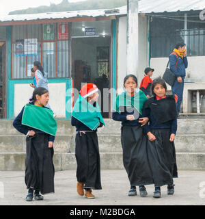 Tungurahua, Ecuador - Dic 20, 2017: giovani indigeni ecuadoriana studentesse post per una foto al di fuori della loro scuola Foto Stock