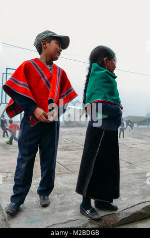 Tungurahua, Ecuador - Dic 20, 2017: giovani indigeni ecuadoriana scolaro e schoolgirl posano per una foto al loro schoolyard Foto Stock