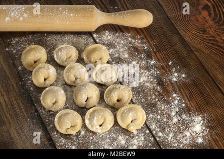 Carne cruda gnocchi e matterello. ripiene gnocchi fatti in casa. Il russo ravioli. Foto Stock