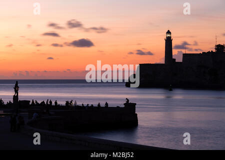 Castillo de los Tres Reyes Magos del Morro e Faro Castillo del Morro faro e persone sedute lungo il seawall all'ingresso della porta. Foto Stock