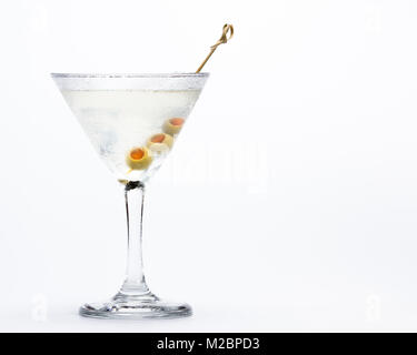 Appena spillata sporco vodka martini con le olive verdi servita su un bicchiere freddo isolato su uno sfondo bianco Foto Stock