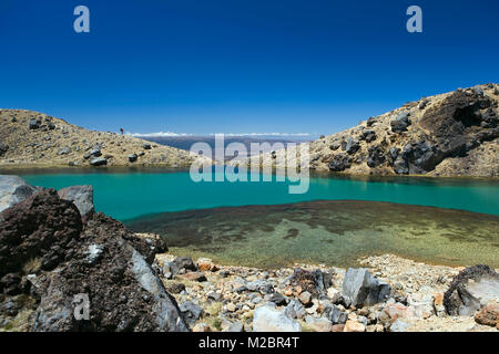 Nuova Zelanda, Isola del nord, Whakapapa, parco nazionale di Tongariro, vista sul Lago Smeraldo. Woman Trekking in background. Unesco World Heritage Site. Foto Stock