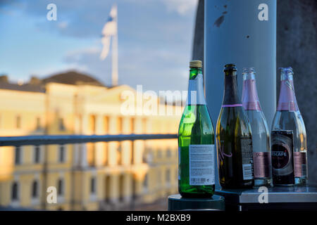 Helsinki, Finlandia - 1 Maggio 2017: bottiglie di vino spumante sulla parte superiore di un cassone presso la Piazza del Senato con il governo finlandese palace sullo sfondo. Foto Stock