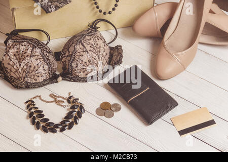 Purse, monete, donna abbigliamento e accessori dopo lo shopping su sfondo di legno. Foto Stock