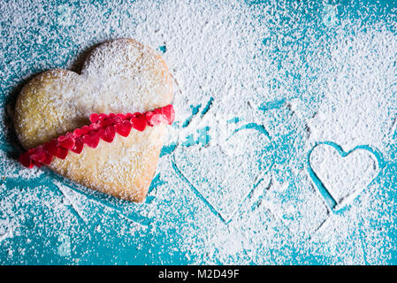 Cottura in forno a forma di cuore i cookie per il giorno di san valentino, su un sfondo azul,vista superiore Foto Stock