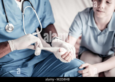 Close up medico del bendaggio mano del ragazzo adolescente Foto Stock