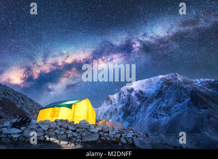 Via Lattea, giallo incandescente tenda e montagne. Incredibile scena con montagna himalayana, cielo stellato di notte in Nepal. Rocce con picco innevato e sky con Foto Stock