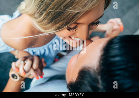 Sorridente coppia caucasica tenendo le mani e lo sfregamento dei nasi Foto Stock
