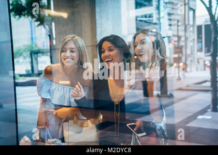 Donna sorridente window shopping Foto Stock