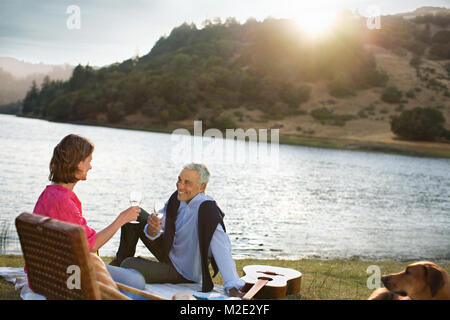 Giovane godendo di vino a waterfront Foto Stock