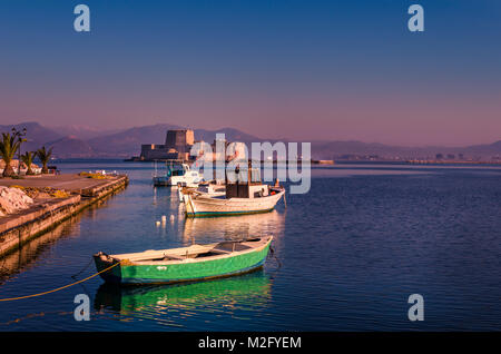 Lo storico castello d'acqua di Bourtzi sullo sfondo e legno di piccole barche da pesca sul primo piano. Foto Stock