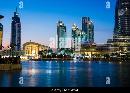 DUBAI, Emirati Arabi Uniti - 5 febbraio 2018: Opera di Dubai e Dubai moderni grattacieli del centro si riflette nell'acqua a ora di blu Foto Stock