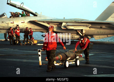 011105-N-6119T-004 a bordo della USS Theodore Roosevelt (CVN 71) (nov. 5, 2001)--due Ordnancemen aviazione della VF-102 'Diamondbacks' spostare inesplosi sul ponte di volo. Il Diamondbacks, un F-14 Tomcat Jet Fighter Squadron, sono parte del Carrier aria Wing uno (CVW 1) distribuito sulla portaerei nucleare sostenendo l Operazione Enduring Freedom dal Mare Arabico. Stati Uniti Navy Foto di Chief Fotografo compagno del Dennis D. Taylor. (Rilasciato) 011105-N-6119T-004 da navalsafetycenter Foto Stock